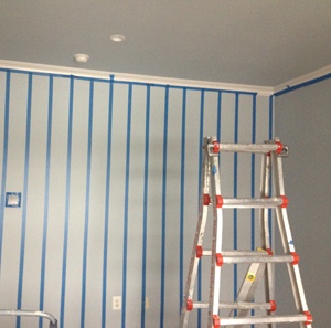 room with blue stripes on white wall and a ladder