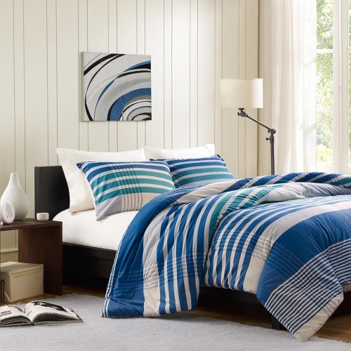 bed with blue pillows and blanket