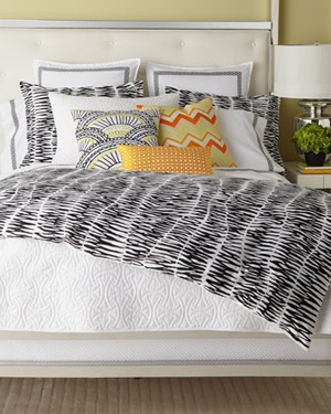 white bed with black and white stripped bedding