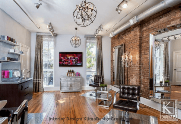 hair salon lounge with brick walls and orb crystal chandelier
