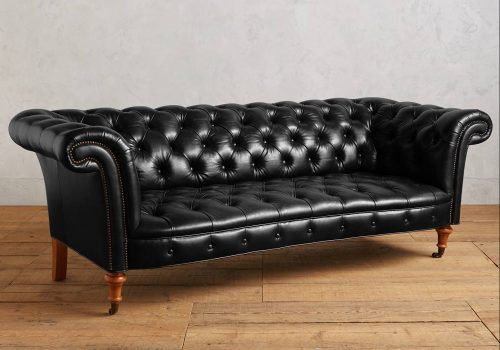 black leather couch in an empty room