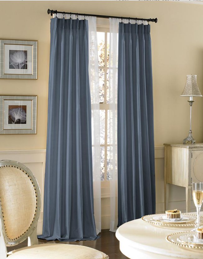 blue extra long curtain in a black curtain rod