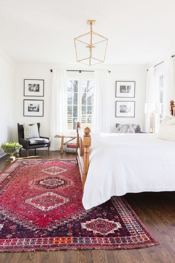 white bedroom with red area rug