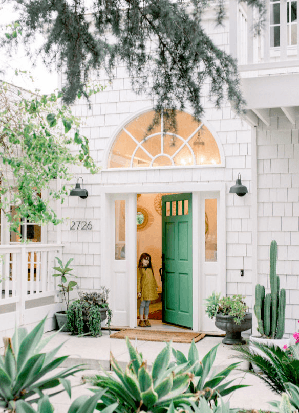green front door with trees and a girl 
