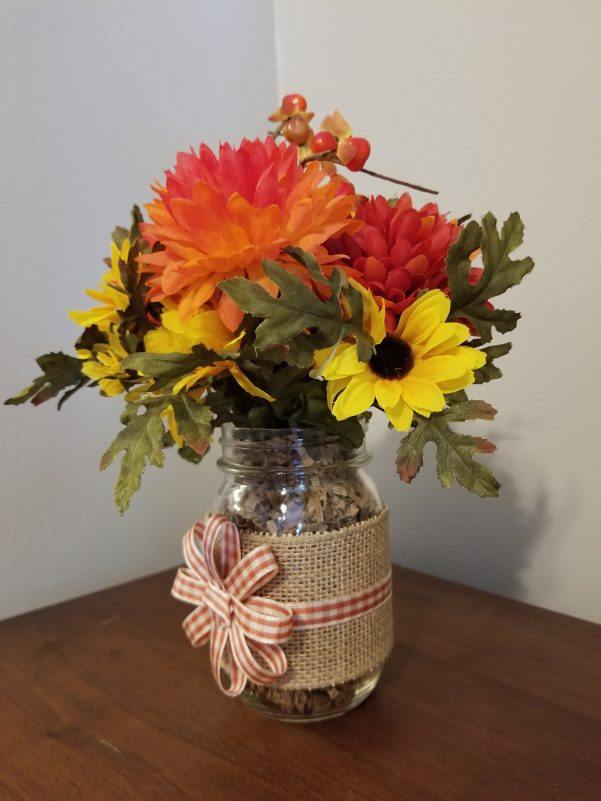 glass jar decorated with flowers 
