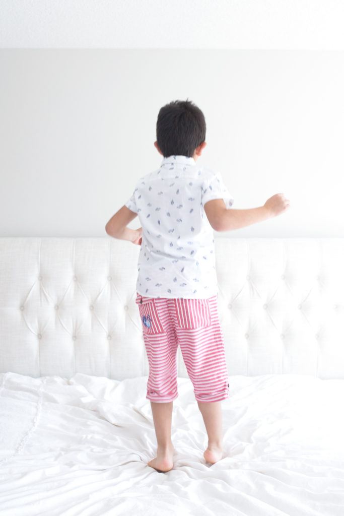 a boy on white bedding 