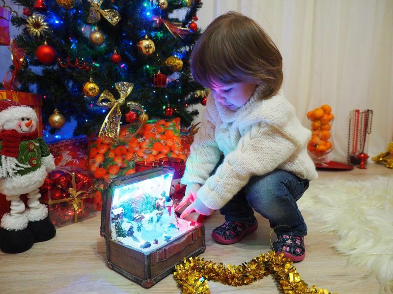 a girl playing with Christmas toys 