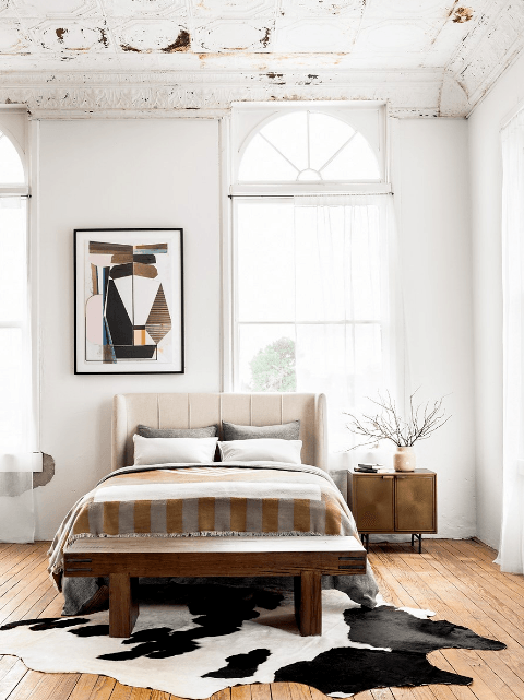 a bedroom with an art piece over the bed that reflects 2020 home decor trends 