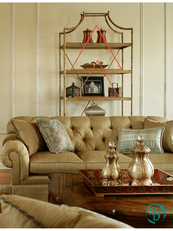 styled etagere with shelves decorated objects behind sofa 